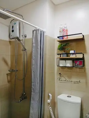 a bathroom with a shower with a toilet and a shower curtain at The Hearth Bliss in Manila