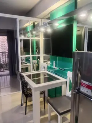 a room with a table and chairs and a refrigerator at Sea residences Sweetest escape in Manila