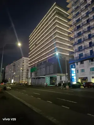 a tall building on a city street at night at Sea residences Sweetest escape in Manila