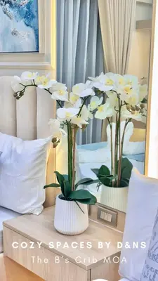 two vases filled with white flowers on a bed at SM MOA Near NAIA Airports The B's Crib MOA in Manila