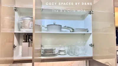 a cupboard with dishes and pots and pans at SM MOA Near NAIA Airports The B's Crib MOA in Manila
