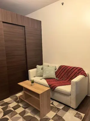a living room with a couch and a table at Pine3s Turf in Manila