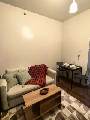 a living room with a couch and a table at Pine3s Turf in Manila