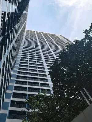 a tall building with trees in front of it at Pine3s Turf in Manila