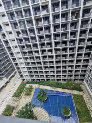 a large apartment building with a swimming pool in front of it at EM's Staycation Walking distance to Mall of Asia in Manila