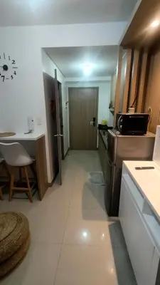 a small kitchen with a table and a refrigerator at EM's Staycation Walking distance to Mall of Asia in Manila