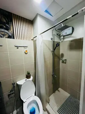 a small bathroom with a toilet and a shower at EM's Staycation Walking distance to Mall of Asia in Manila