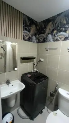 a bathroom with a sink and a toilet and a mirror at EM's Staycation Walking distance to Mall of Asia in Manila