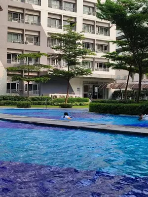 a swimming pool in front of a large building at SMDC Grace Residences Tower 4 in Manila