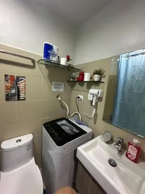 a bathroom with a toilet and a sink and a mirror at Gateway Mall of asia Shore 3 in Manila