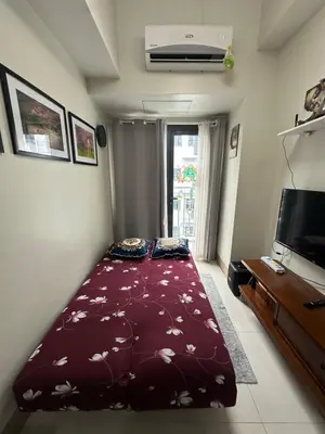 a bedroom with a large bed with a red comforter at Gateway Mall of asia Shore 3 in Manila