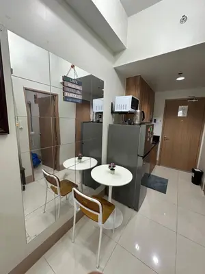 a kitchen with two tables and a refrigerator at Gateway Mall of asia Shore 3 in Manila