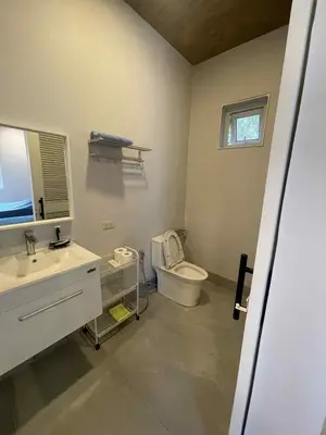 a bathroom with a toilet and a sink at Pleasant Hill Cabins near Tagaytay Highlands