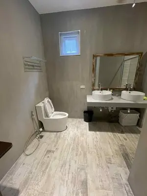 a bathroom with two sinks and a toilet and a mirror at Pleasant Hill Cabins near Tagaytay Highlands