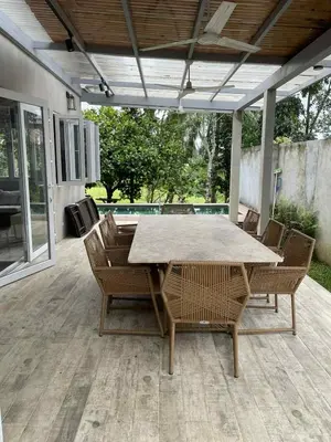a wooden table and chairs on a patio at Pleasant Hill Cabins near Tagaytay Highlands