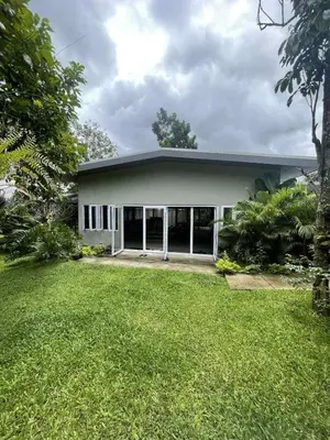a large white house with a grass yard at Pleasant Hill Cabins near Tagaytay Highlands