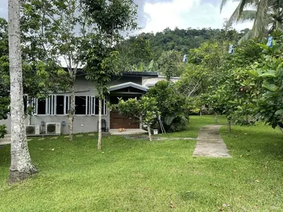 a white house with a yard with a driveway at Pleasant Hill Cabins near Tagaytay Highlands