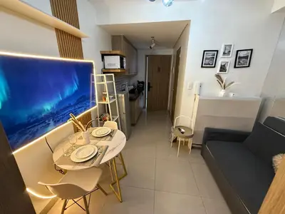 a living room with a table and a large aquarium at The Celestia Bay at Shore 2 Residences in Manila