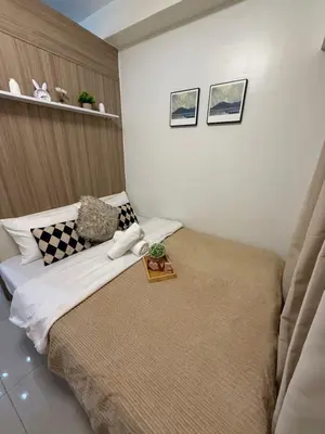 a bedroom with a large bed with a brown headboard at The Celestia Bay at Shore 2 Residences in Manila