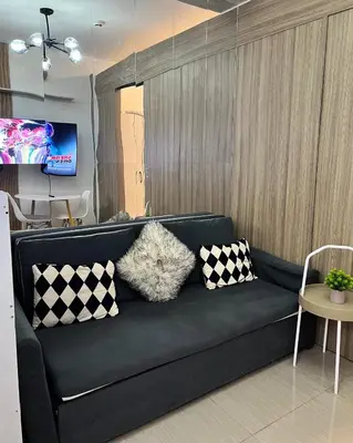 a black couch with pillows in a living room at The Lumora Cove at Shore 2 Residences in Manila