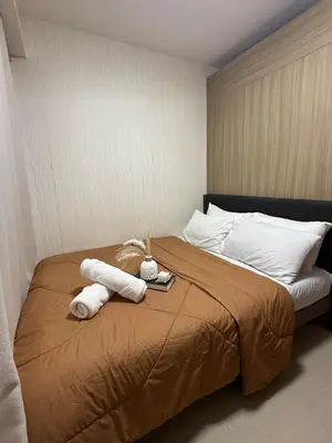 a bedroom with a bed with towels on it at The Grand Haven at Shore Residences in Manila