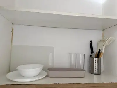 a shelf with bowls and utensils on it at The Grand Haven at Shore Residences in Manila