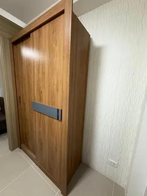 a wooden door in the corner of a room at The Grand Haven at Shore Residences in Manila