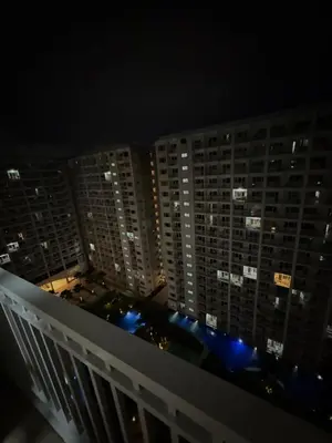 a view from the balcony of a building at night at The Grand Haven at Shore Residences in Manila
