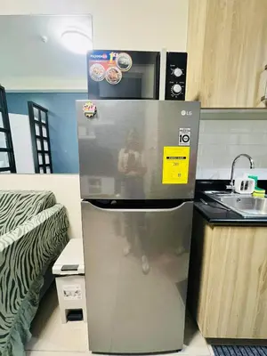 a stainless steel refrigerator in a kitchen with a sink at The Sunset Cozy Suite at Shore 1 in Manila