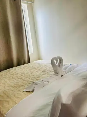 a bed with two swans made to look like hearts at The Sunset Cozy Suite at Shore 1 in Manila