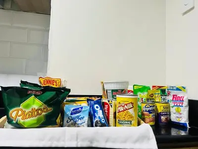 a pile of chips and other snacks on a table at The Sunset Cozy Suite at Shore 1 in Manila