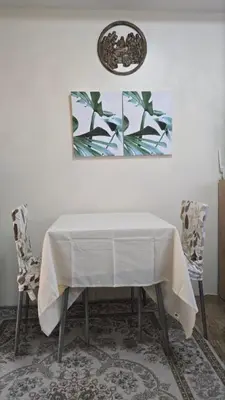a dining room table with a white tablecloth and two chairs at The Cozy Place in Silang