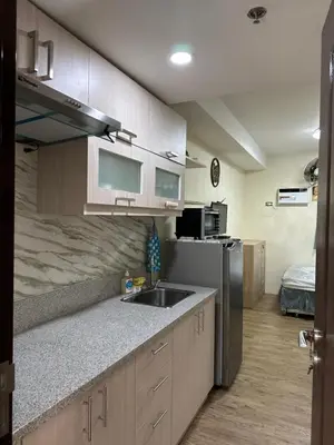 a kitchen with a sink and a refrigerator at The Cozy Place in Silang