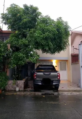 a truck parked under a tree in a driveway at Modern 2 Storey 2BR Home with 2 Parking Space in Manila