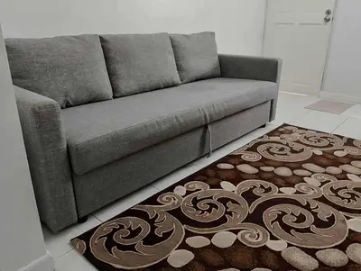 a grey couch in a living room with a rug at Modern 2 Storey 2BR Home with 2 Parking Space in Manila