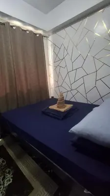 a room with a bed with a blue table with a sqor at Chen Staycation at Shore in Manila