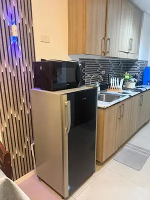 a kitchen with a tv on top of a refrigerator at Chen Staycation at Shore in Manila