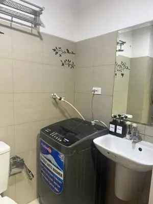 a bathroom with a sink and a toilet and a mirror at Chen Staycation at Shore in Manila