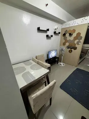 a living room with a table and a couch and a television at Sea Residence Condotel Tower E&F in Manila
