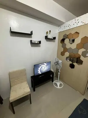 a living room with a tv and a chair at Sea Residence Condotel Tower E&F in Manila