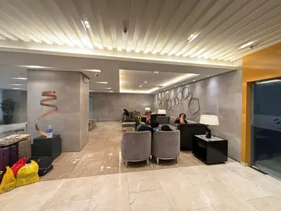 a lobby with people sitting in chairs in a building at Vera's Place in Mall of Asia Complex in Manila