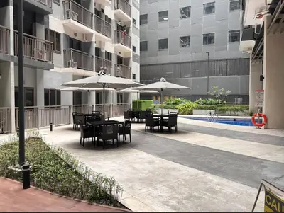 a patio with tables and umbrellas in a building at Vera's Place in Mall of Asia Complex in Manila