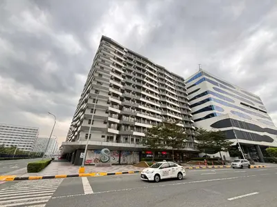 a white car parked in front of two tall buildings at Vera's Place in Mall of Asia Complex in Manila