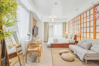 a living room with a couch and a bed at Japandi Aesthetic Corner Unit, Calm & Private, MOA in Manila