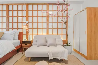 a bedroom with a white bed and a chair at Japandi Aesthetic Corner Unit, Calm & Private, MOA in Manila