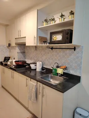 a kitchen with a sink and a microwave at Ana's Homestay at Sea Residences in Manila