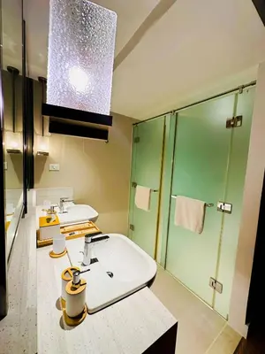 a bathroom with two sinks and a shower at DE LUX SUITE at Novotel Manila Hotel Residences Acqua in Manila