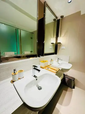 a bathroom with two sinks and a large mirror at DE LUX SUITE at Novotel Manila Hotel Residences Acqua in Manila