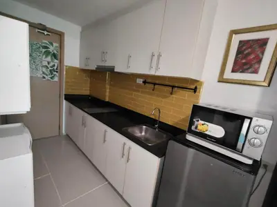 a small kitchen with a sink and a microwave at Lornas Place in Manila