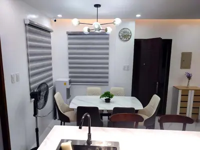 a dining room with a white table and chairs at Modern 3BR Cozy Homestay Antipolo in Antipolo